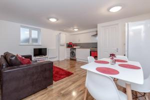 a living room with a white table and a couch at Royal Apartments - Heathrow in Hillingdon