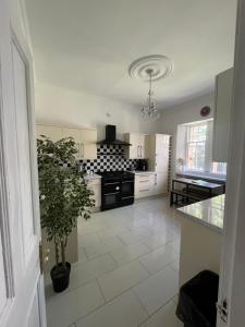 a kitchen with a black stove and a white tile floor at West End Beds in Dundee