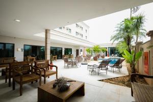 a patio with chairs and tables and a pool at Class Hotel Pouso Alegre in Pouso Alegre