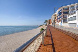 a boardwalk on the beach next to some buildings at Apartament Platja L'arquitecte in L'Ampolla