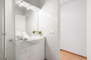 a white bathroom with a sink and a shower at Apartament Platja L'arquitecte in L'Ampolla +22 photos