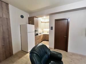 a kitchen with a black leather chair and a refrigerator at Dadiani Apartment in Tbilisi City
