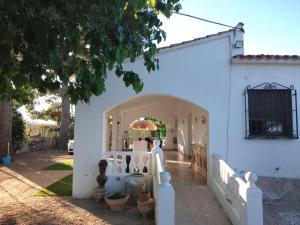 a white house with a white fence and a gate at Rustic Chalet With Easy Golf Beach Access Oliva Nova in Oliva