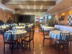 a dining room with tables and chairs with white tablecloths at Suite Premium Vista Panorámica in Santa Teresita