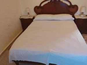 a bedroom with a large bed with a wooden headboard at Rustic Chalet With Easy Golf Beach Access Oliva Nova in Oliva +7 photos