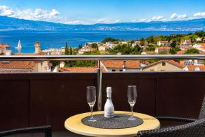 a table with two glasses and a bottle of wine at Apartments Kvarner 2 in Malinska