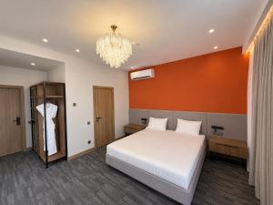 a bedroom with a bed and a chandelier at Metropol Hotel Bishkek in Bishkek