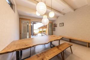 a dining room with a wooden table and benches at UG HOSTEL Takayama in Takayama +62 photos