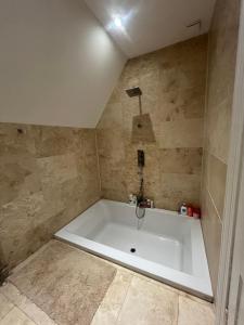 a large white tub in a bathroom with a tile floor at West End Beds in Dundee +15 photos