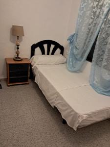 a bedroom with two beds and a table with a lamp at Rustic Chalet With Easy Golf Beach Access Oliva Nova in Oliva