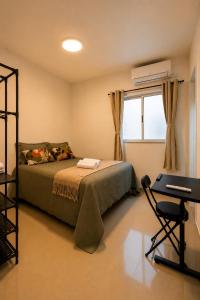 a bedroom with a bed and a desk and a window at Ap Go travel in São Luís