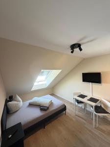 a bedroom with a bed and a desk with a television at NB14-1 Living in Weingarten (Karlsruhe)