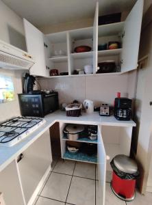 a small kitchen with white cabinets and a stove at Duplex en plein centre du village in Voreppe