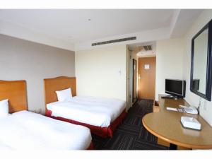Säng eller sängar i ett rum på Kanku Izumiotsu Washington Hotel