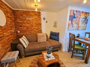 a living room with a couch and a table at Coastline Apartments in Fuhlendorf