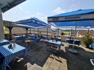 a patio with blue tables and blue umbrellas at Hotel Restaurant Ampertal in Haag an der Amper