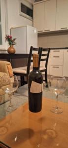 a bottle of wine sitting on a table with two glasses at Parking free in Mostar