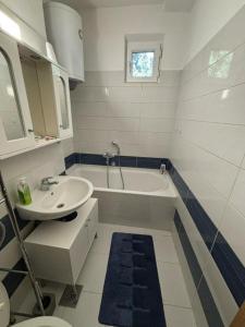 a bathroom with a sink and a tub and a toilet at Parking free in Mostar