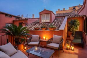 a patio with chairs and a table on a balcony at Hotel Della Torre Argentina in Rome
