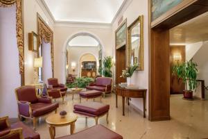 a lobby of a hotel with chairs and tables at Hotel Della Torre Argentina in Rome