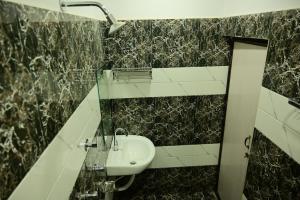 a bathroom with a sink and a mirror at Hotel Parineeta in Khagaria +12 photos