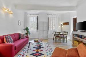 a living room with a red couch and a table at Appartement Provençal in Cotignac