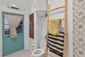 a bathroom with a toilet and a blue door at Appartement Provençal in Cotignac