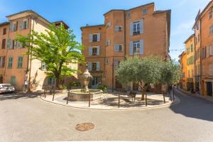 a courtyard with a fountain in front of buildings at Appartement Provençal in Cotignac