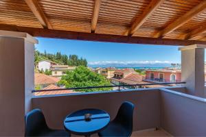 a balcony with a table and a view of the city at Stay Easy Sidari Apartments in Sidari