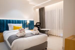 two white rabbits sitting on a bed in a bedroom at Clubway Grand A Boutique Hotel Jorhat in Jorhāt +25 photos