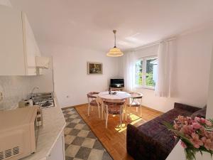 a kitchen and living room with a table and a couch at Apartments Dragica in Šilo