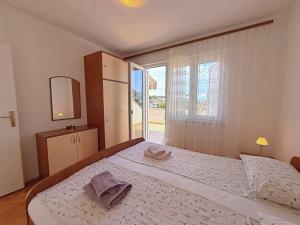 a bedroom with a large bed and a window at Apartments Dragica in Šilo