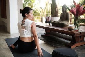 a woman doing a yoga pose in front of a table at Casa Origen Los Naranjos in Los Naranjos