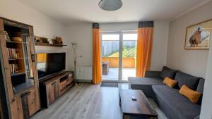 a living room with a couch and a television at Ferienwohnung in Birkenwerder mit Balkon in Birkenwerder