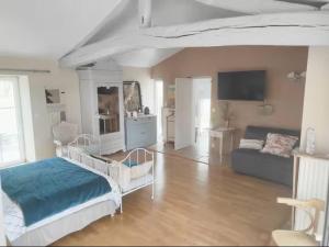 a living room with a bed and a couch at Les Jardins de la Pinellerie in Vue