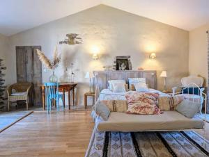 a living room with a bed and a table at Les Jardins de la Pinellerie in Vue