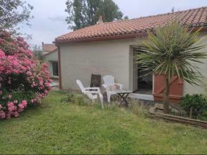 two white chairs sitting on the porch of a house at Les Jardins de la Pinellerie in Vue