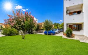a green lawn in front of a building at Apartments Kvarner 2 in Malinska +48 photos