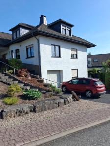 a red car parked in front of a house at Ferienwohnung Wirtz in Olzheim