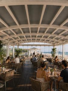 a group of people sitting at tables in a restaurant at Virgilio Grand Hotel in Sperlonga +50 photos