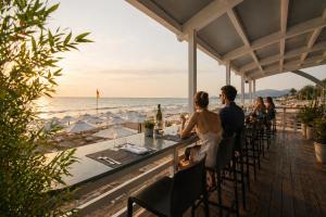 a couple sitting at a bar overlooking the beach at Virgilio Grand Hotel in Sperlonga