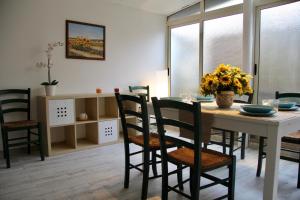 ジャルディーニ・ナクソスにあるFederico's Homeのダイニングルーム(椅子とテーブル、花付)