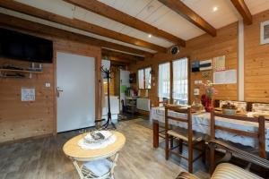 a room with wooden walls and a table and chairs at Chalet des Charbonneux, nature in Le Ménil