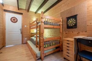 a bedroom in a log cabin with bunk beds at Chalet des Charbonneux, nature in Le Ménil