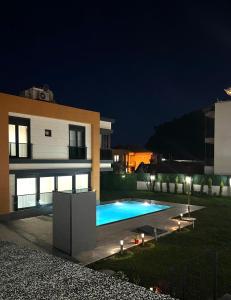 a swimming pool in front of a house at night at Riviera Villa Kemer in Agva