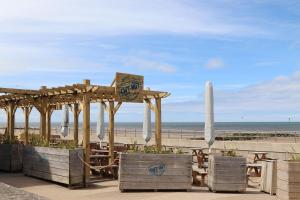 a wooden pavilion with chairs and umbrellas on the beach at 6 Bastion Close in Prestatyn
