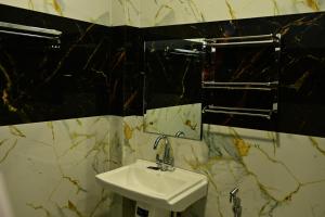 a bathroom with a sink and a mirror at Hotel Parineeta in Khagaria