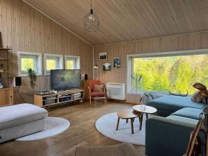 a living room with a couch and a tv at Exclusive Designer Cabin - Panoramic Mountain View in Vossevangen