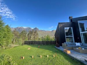 a house with a yard with a couch in the grass at Exclusive Designer Cabin - Panoramic Mountain View in Vossevangen