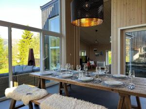 a dining table with wine glasses on it in a living room at Exclusive Designer Cabin - Panoramic Mountain View in Vossevangen